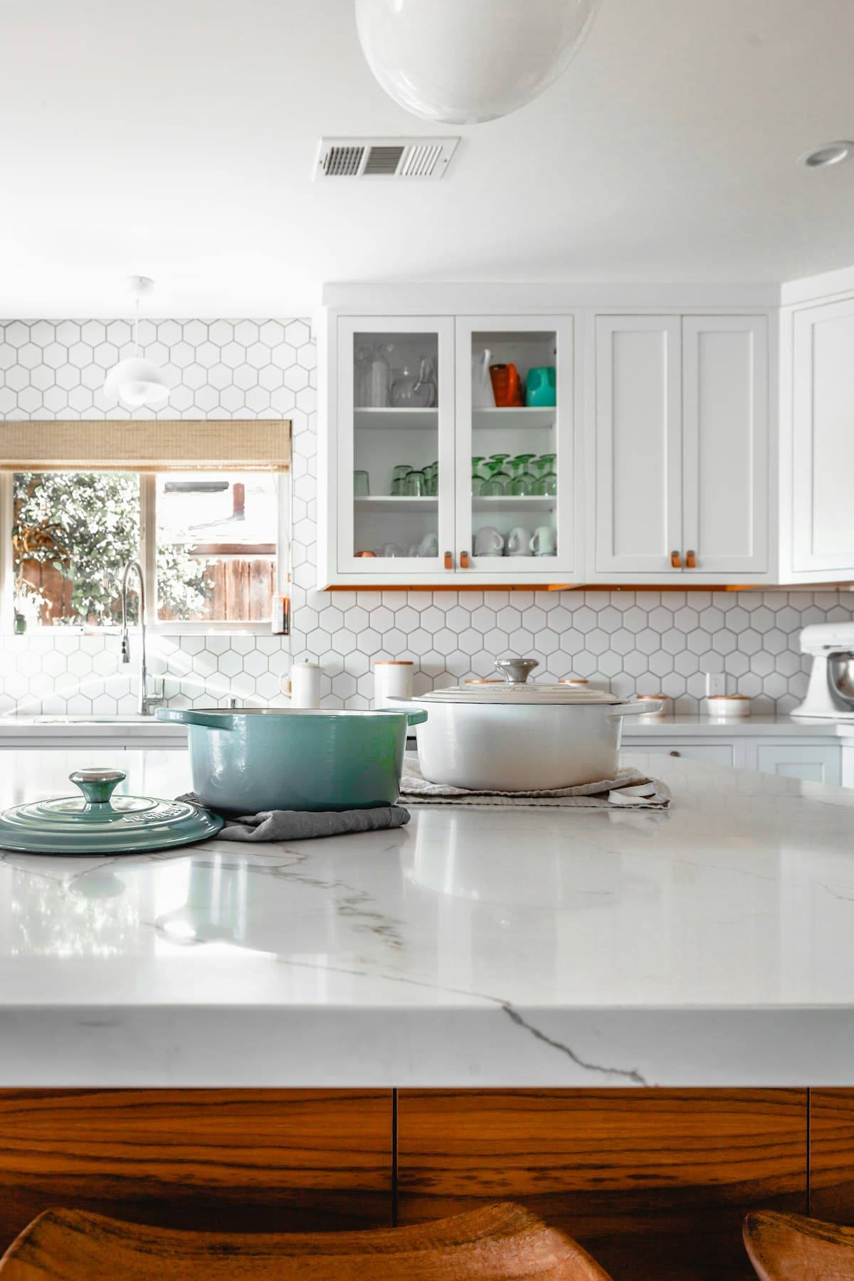 Bright, organized kitchen with clean marble counters and white cabinetry